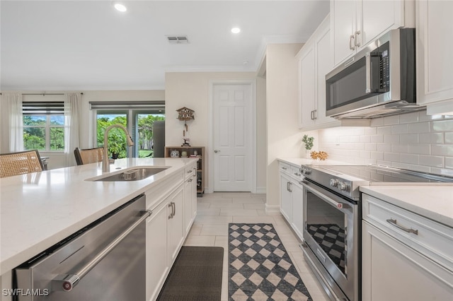 374 Deauville Loop, Naples, FL 34114 - kitchen featuring appliances with stainless steel finishes, light countertops, ornamental molding, tasteful backsplash, and white cabinetry
