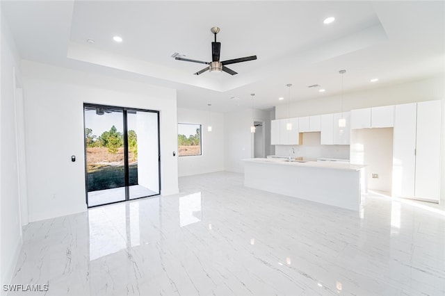 1268 Hillcrest St E, Lehigh Acres, FL 33974 - unfurnished living room featuring a raised ceiling, recessed lighting, light marble finish floors, and ceiling fan