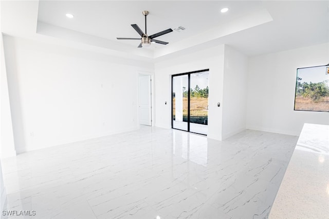 1268 Hillcrest St E, Lehigh Acres, FL 33974 - spare room featuring a tray ceiling, recessed lighting, ceiling fan, and light marble finish flooring