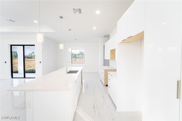 1268 Hillcrest St E, Lehigh Acres, FL 33974 - kitchen with modern cabinets, light marble finish floors, white cabinetry, a kitchen island with sink, and recessed lighting