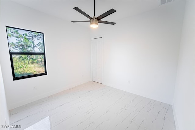 1268 Hillcrest St E, Lehigh Acres, FL 33974 - spare room with light marble finish floors and a ceiling fan