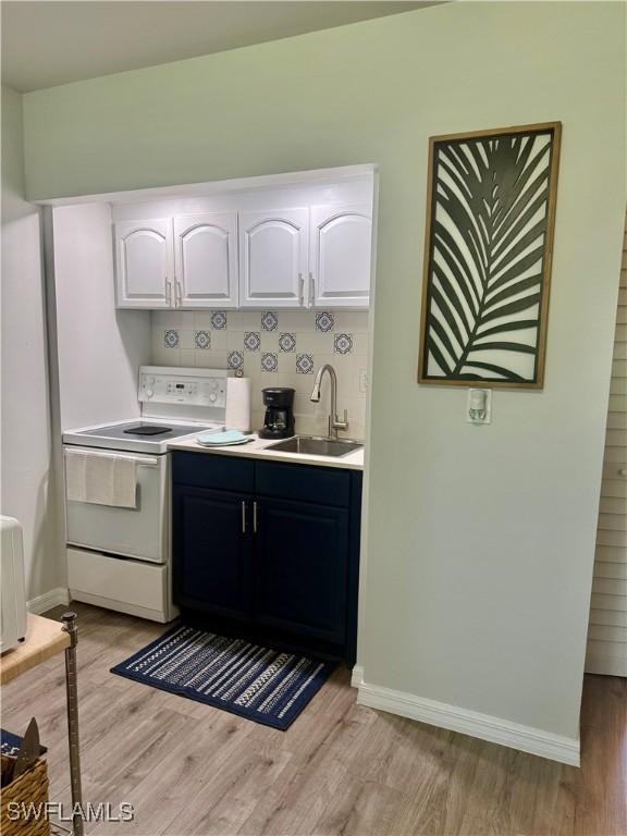 240 N Collier Blvd Unit A3, Marco Island, FL 34145 - kitchen featuring white electric stove, light wood-style floors, white cabinetry, and light countertops