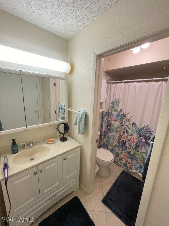 6300 S Pointe Blvd Unit 459, Fort Myers, FL 33919 - bathroom with tile patterned floors, vanity, a textured ceiling, and a shower with curtain