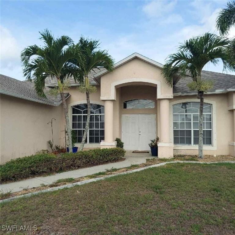 1804 El Dorado Blvd N, Cape Coral, FL 33993 - view of exterior entry featuring stucco siding and a yard