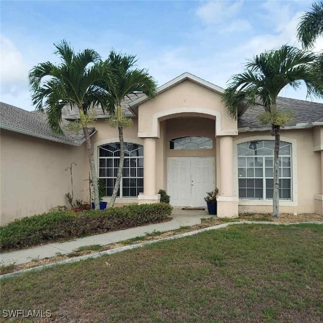 1804 El Dorado Blvd N, Cape Coral, FL 33993 - view of exterior entry featuring stucco siding and a yard