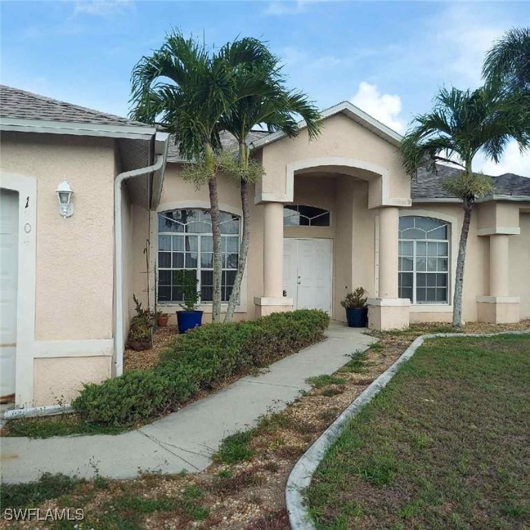1804 El Dorado Blvd N, Cape Coral, FL 33993 - view of exterior entry featuring stucco siding and a shingled roof