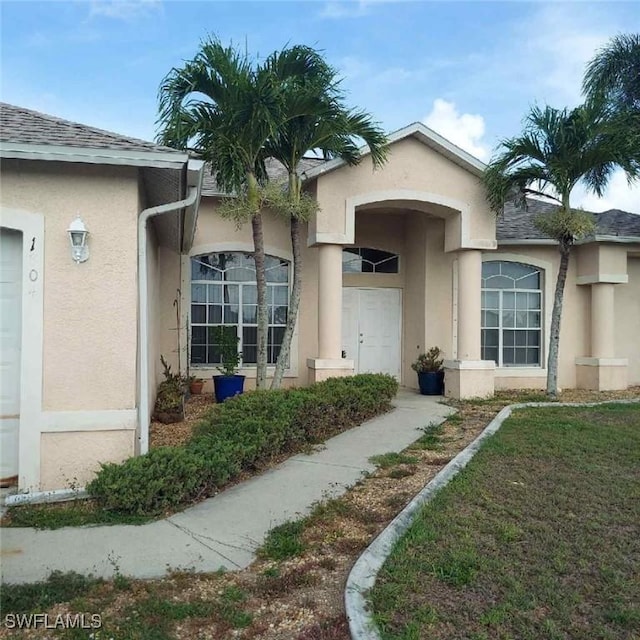 1804 El Dorado Blvd N, Cape Coral, FL 33993 - view of exterior entry featuring stucco siding and a shingled roof