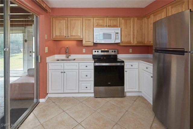 1721 Smugglers Cv, Naples, FL 34112 - kitchen featuring stainless steel appliances, light countertops, light tile patterned flooring, and white cabinets