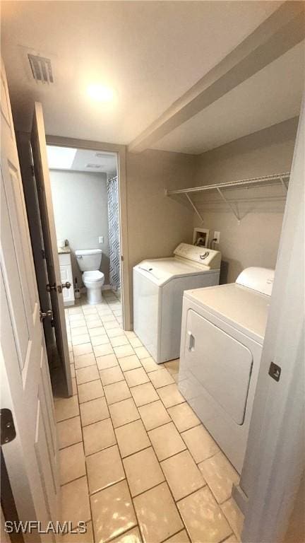 606 Gerald Ave Unit 115, Lehigh Acres, FL 33936 - laundry room featuring washer and dryer and light tile patterned flooring