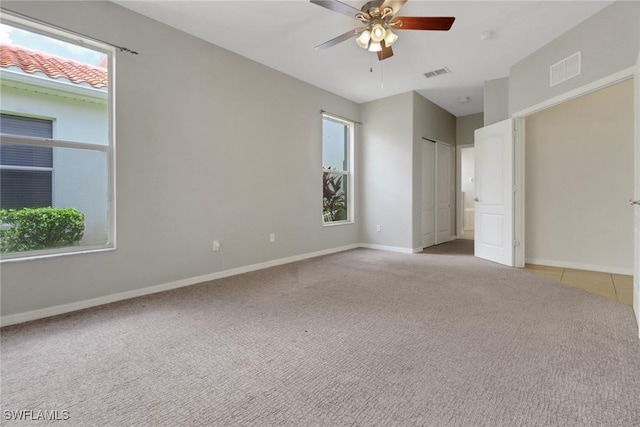 8677 Pegasus Dr, Lehigh Acres, FL 33971 - unfurnished bedroom featuring light carpet, multiple windows, and ceiling fan