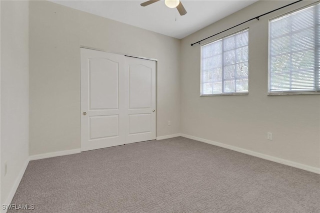 8677 Pegasus Dr, Lehigh Acres, FL 33971 - unfurnished bedroom featuring multiple windows, carpet flooring, a closet, and a ceiling fan