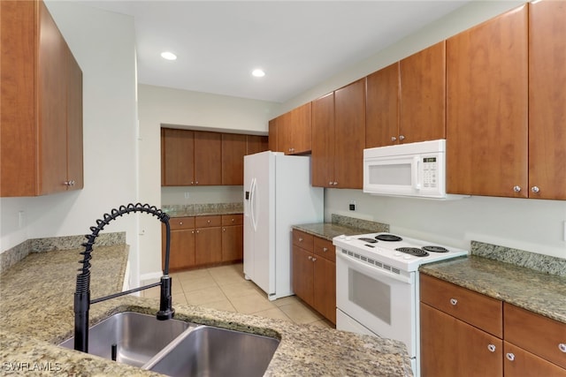 8677 Pegasus Dr, Lehigh Acres, FL 33971 - kitchen with white appliances, brown cabinets, light tile patterned flooring, light stone counters, and recessed lighting
