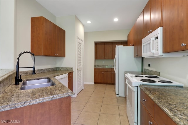 8677 Pegasus Dr, Lehigh Acres, FL 33971 - kitchen with white appliances, brown cabinetry, light tile patterned flooring, stone countertops, and recessed lighting