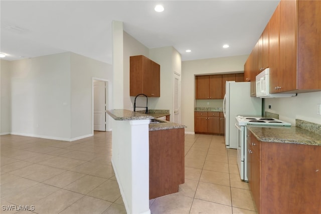 8677 Pegasus Dr, Lehigh Acres, FL 33971 - kitchen featuring white appliances, light tile patterned flooring, stone counters, brown cabinets, and a peninsula