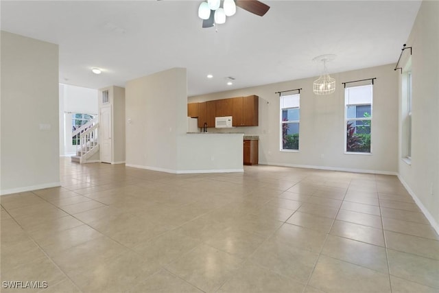 8677 Pegasus Dr, Lehigh Acres, FL 33971 - unfurnished living room featuring light tile patterned floors, a ceiling fan, and stairs