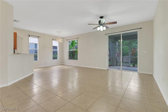 8677 Pegasus Dr, Lehigh Acres, FL 33971 - unfurnished room with light tile patterned flooring, a ceiling fan, and a chandelier