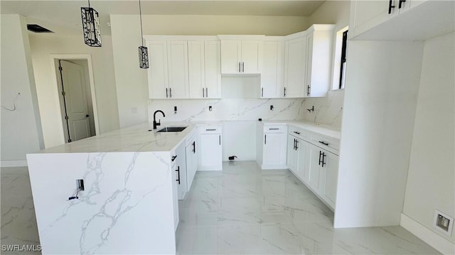 2503 46th St SW, Lehigh Acres, FL 33976 - kitchen featuring light marble finish flooring, light stone countertops, white cabinetry, and decorative light fixtures