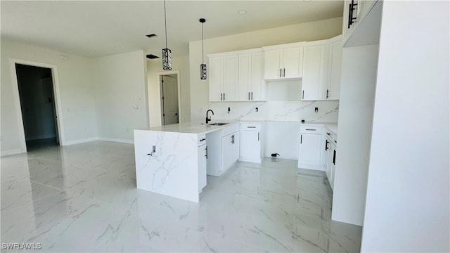 2503 46th St SW, Lehigh Acres, FL 33976 - kitchen featuring backsplash, decorative light fixtures, white cabinets, and light marble finish floors