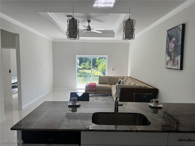 595 Carolina Ave, Fort Myers, FL 33905 - kitchen with dark stone counters, a raised ceiling, open floor plan, a ceiling fan, and crown molding