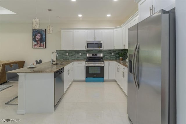 595 Carolina Ave, Fort Myers, FL 33905 - kitchen featuring stainless steel appliances, a peninsula, decorative backsplash, dark stone counters, and white cabinetry