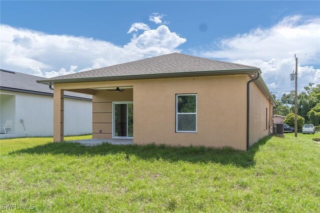 595 Carolina Ave, Fort Myers, FL 33905 - rear view of house with a yard, stucco siding, and a ceiling fan
