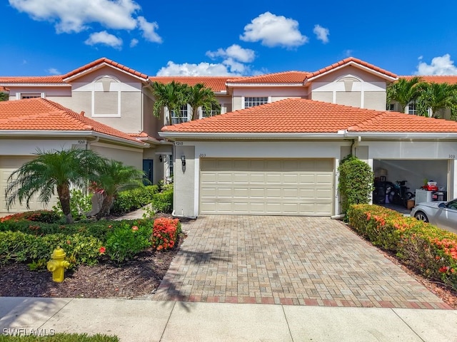 9260 Belleza Way Unit 203, Fort Myers, FL 33908 - mediterranean / spanish home featuring an attached garage, driveway, a tiled roof, and stucco siding