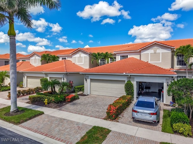 9260 Belleza Way Unit 203, Fort Myers, FL 33908 - view of front of home with an attached garage, a tile roof, decorative driveway, and stucco siding