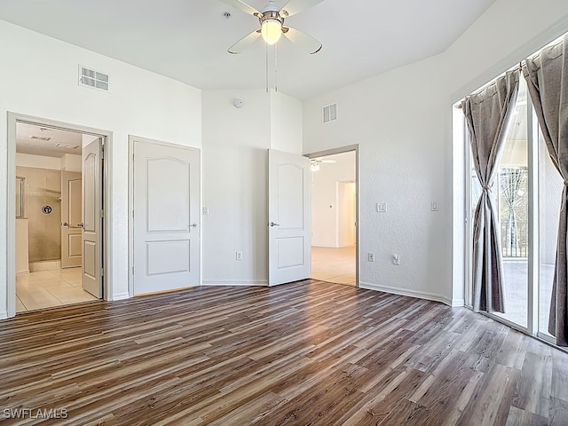 9260 Belleza Way Unit 203, Fort Myers, FL 33908 - unfurnished bedroom with access to outside, wood finished floors, ensuite bathroom, a ceiling fan, and a towering ceiling