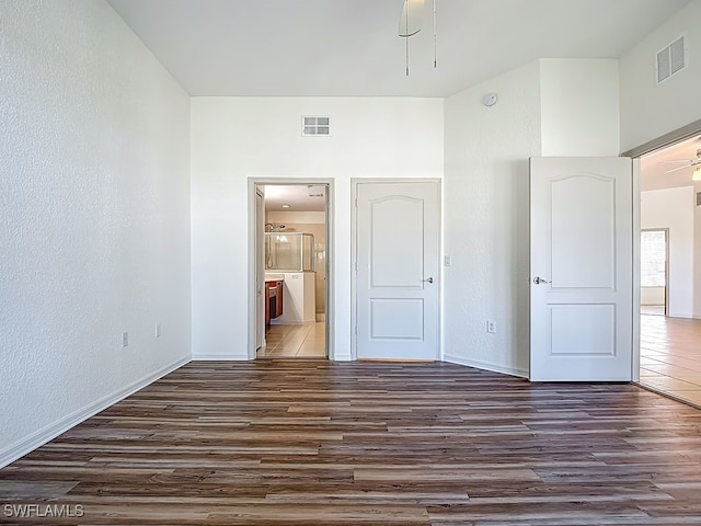 9260 Belleza Way Unit 203, Fort Myers, FL 33908 - unfurnished bedroom featuring dark wood finished floors, ensuite bath, and a textured wall