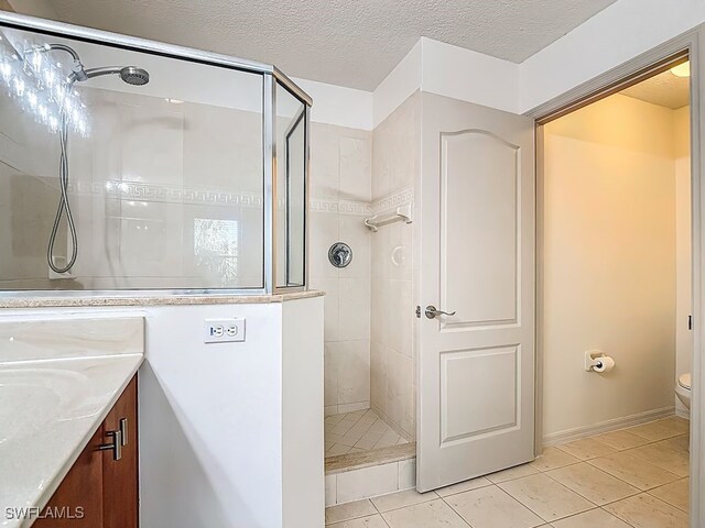 9260 Belleza Way Unit 203, Fort Myers, FL 33908 - full bathroom with a tile shower, tile patterned floors, vanity, and a textured ceiling