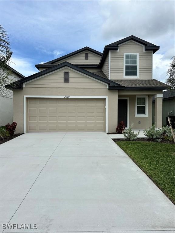 17573 Monte Isola Way N, Fort Myers, FL 33917 - traditional-style home with driveway, an attached garage, stucco siding, a shingled roof, and a front lawn