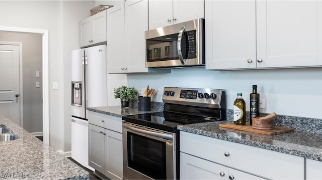 17573 Monte Isola Way N, Fort Myers, FL 33917 - kitchen featuring appliances with stainless steel finishes, white cabinetry, and dark stone countertops