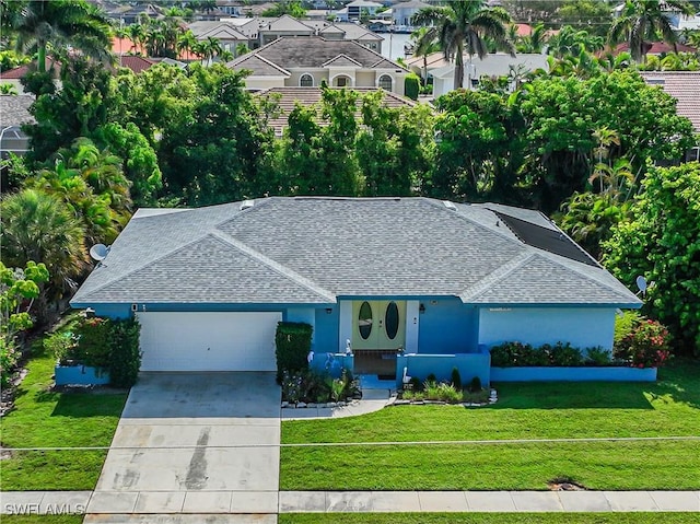 211 W Flamingo Cir, Marco Island, FL 34145 - view of front of property featuring roof with shingles, an attached garage, concrete driveway, and a front yard
