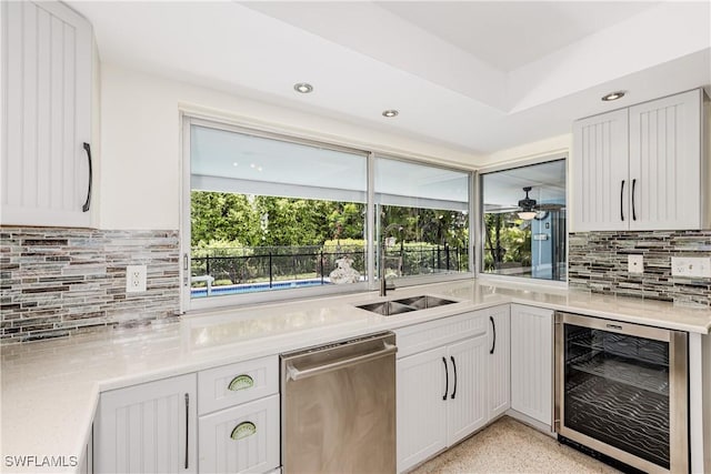 211 W Flamingo Cir, Marco Island, FL 34145 - kitchen with wine cooler, stainless steel dishwasher, decorative backsplash, light countertops, and recessed lighting