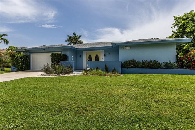 211 W Flamingo Cir, Marco Island, FL 34145 - view of front facade featuring driveway, stucco siding, a garage, and a front yard