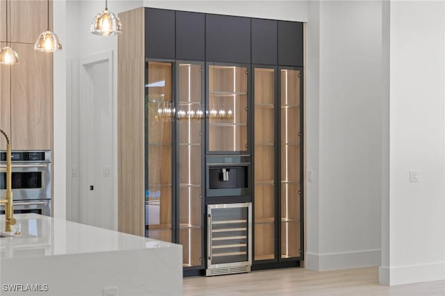 3620 SW 4th Ln, Cape Coral, FL 33991 - detailed view of wine cooler, double oven, light wood-type flooring, modern cabinets, and dark cabinetry