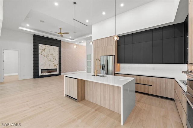 3620 SW 4th Ln, Cape Coral, FL 33991 - kitchen with modern cabinets, high end refrigerator, a fireplace, a ceiling fan, and light brown cabinets