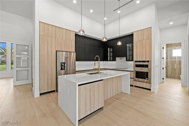 3620 SW 4th Ln, Cape Coral, FL 33991 - kitchen with modern cabinets, a high ceiling, appliances with stainless steel finishes, plenty of natural light, and light brown cabinetry