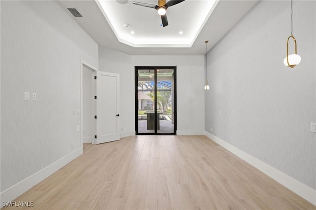 3620 SW 4th Ln, Cape Coral, FL 33991 - empty room featuring light wood finished floors, a tray ceiling, ceiling fan, and a smoke detector