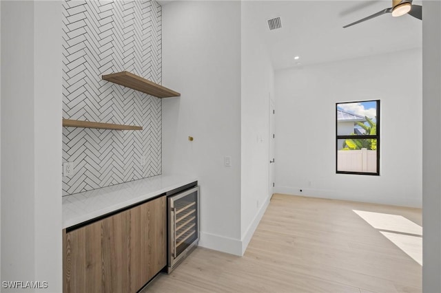 3620 SW 4th Ln, Cape Coral, FL 33991 - indoor dry bar featuring wine cooler, light wood finished floors, a ceiling fan, and tasteful backsplash