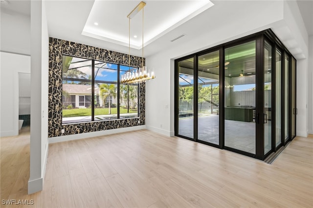3620 SW 4th Ln, Cape Coral, FL 33991 - unfurnished dining area featuring a raised ceiling, wood finished floors, and a chandelier