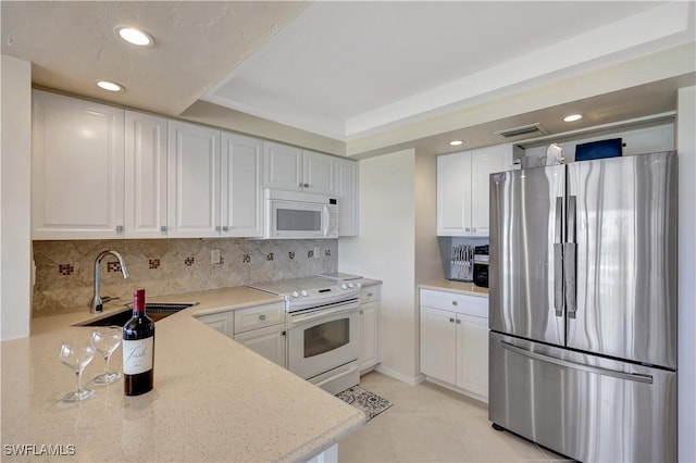 1080 S Collier Blvd Unit 305, Marco Island, FL 34145 - kitchen with white appliances, tasteful backsplash, white cabinets, light tile patterned flooring, and recessed lighting