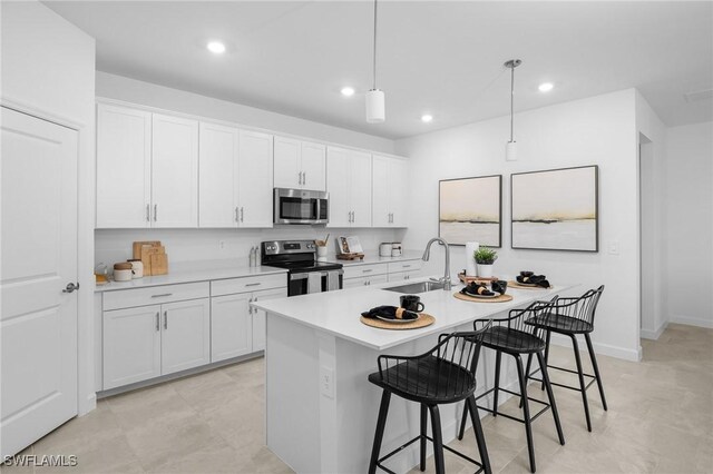 17752 Saddleback Loop, North Fort Myers, FL 33917 - kitchen with stainless steel appliances, a kitchen bar, light countertops, recessed lighting, and white cabinets