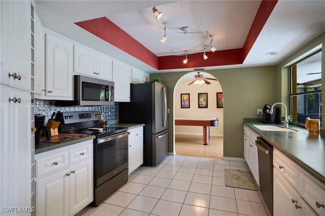 17139 Knight Dr, Fort Myers, FL 33967 - kitchen with appliances with stainless steel finishes, dark countertops, white cabinetry, decorative backsplash, and track lighting