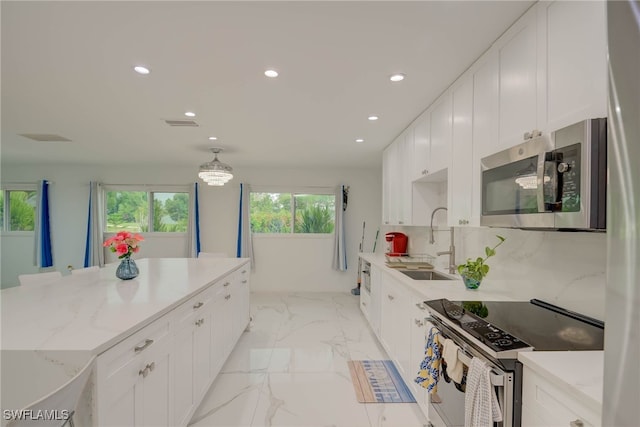 14539 Riverside Dr, Fort Myers, FL 33905 - kitchen featuring stainless steel appliances, recessed lighting, white cabinetry, light marble finish flooring, and light stone countertops