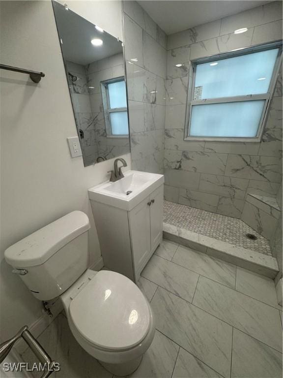 2590 1st St Unit 112, Fort Myers, FL 33901 - bathroom featuring tiled shower, vanity, and marble look tiles