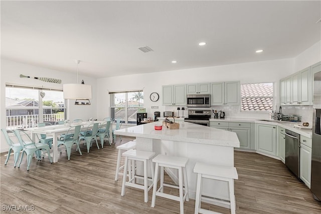 1218 Treasure Ct, Marco Island, FL 34145 - kitchen featuring stainless steel appliances, light countertops, wood finished floors, tasteful backsplash, and recessed lighting