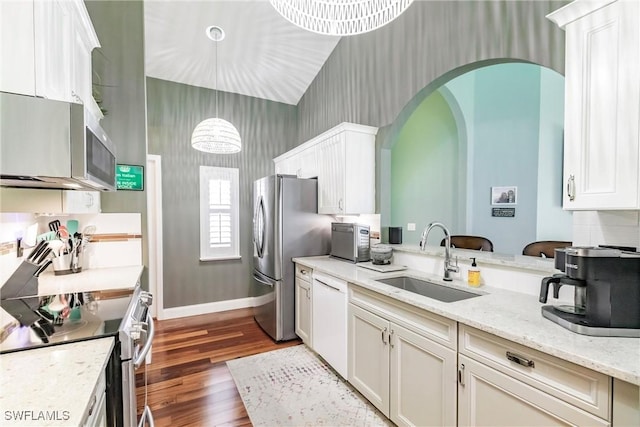 15139 Ligustrum Ln, Alva, FL 33920 - kitchen featuring appliances with stainless steel finishes, dark wood-type flooring, arched walkways, white cabinets, and light stone counters