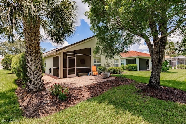 15139 Ligustrum Ln, Alva, FL 33920 - rear view of house with stucco siding, a sunroom, a lawn, and a patio area