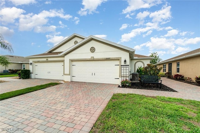 20095 Fiddlewood Ave, North Fort Myers, FL 33917 - ranch-style house with decorative driveway, stucco siding, and an attached garage